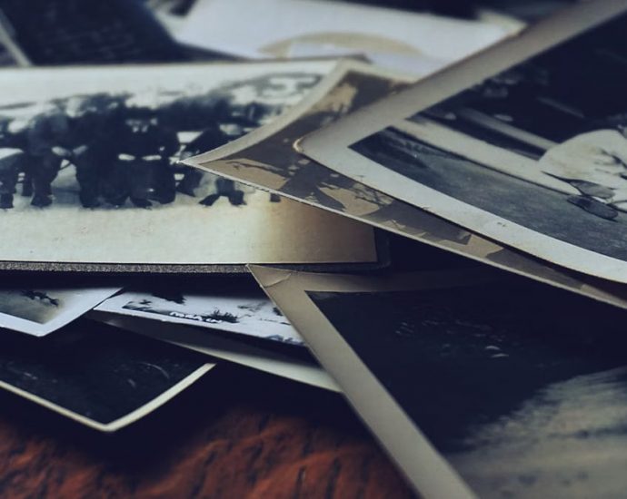 A stack of classic black and white photographs showcasing family memories and history.