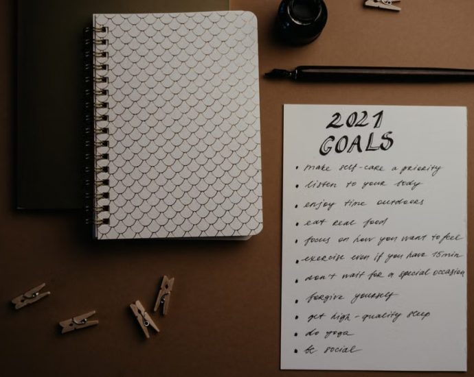 Aesthetic flatlay of notebooks and a 2021 goals list in elegant calligraphy.